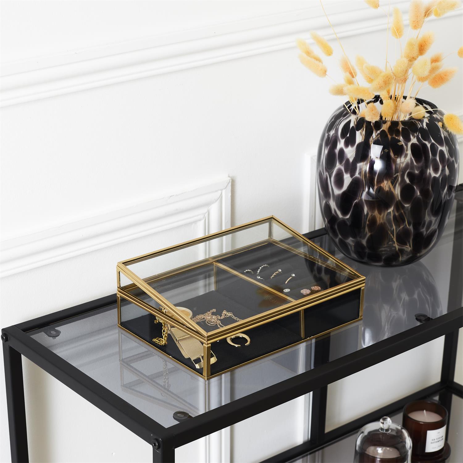 Boîte de rangement en verre avec intérieur en velours noir, idéale pour ranger et trier les bijoux sur la coiffeuse.