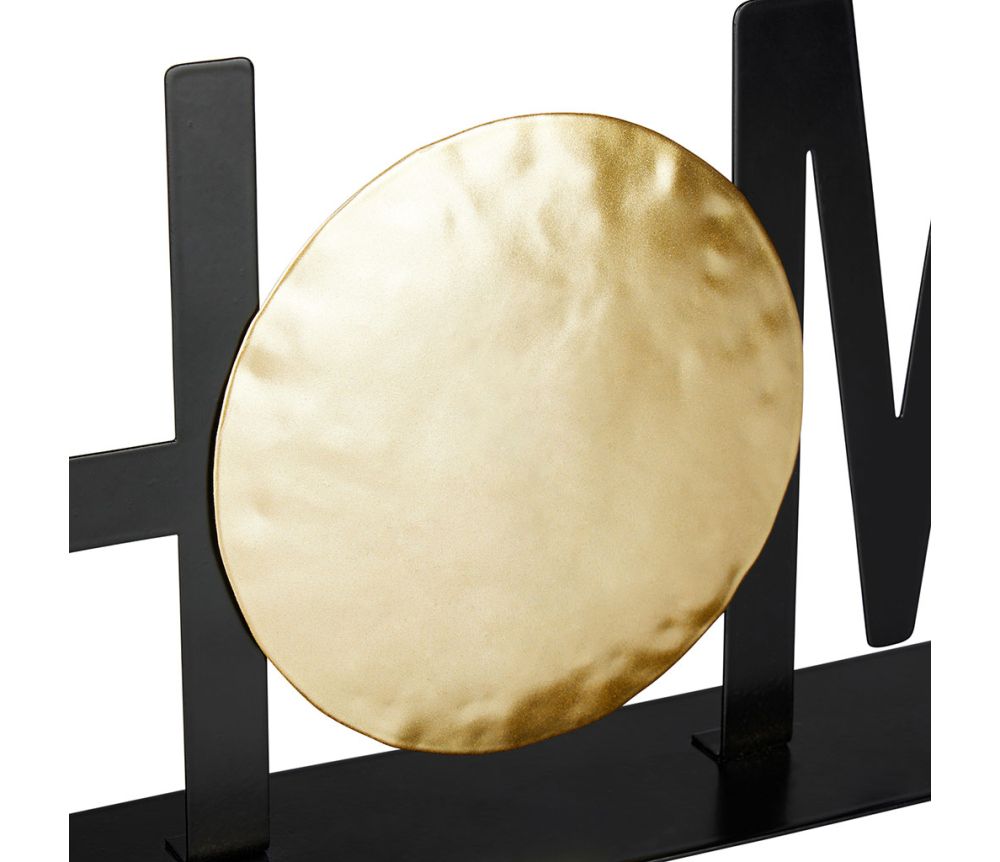 Mot déco "Home" en métal noir et or posé sur une étagère