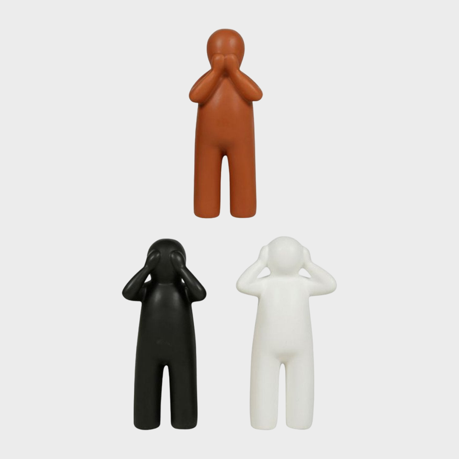 Figurines en céramique de personnages noirs, blancs et oranges, apportant une touche amusante et originale à la décoration intérieure.